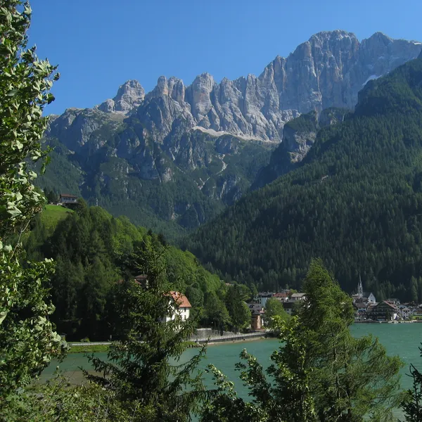 Lake Alleghe with the village on its shore and the walls of the Civetta above, in summer