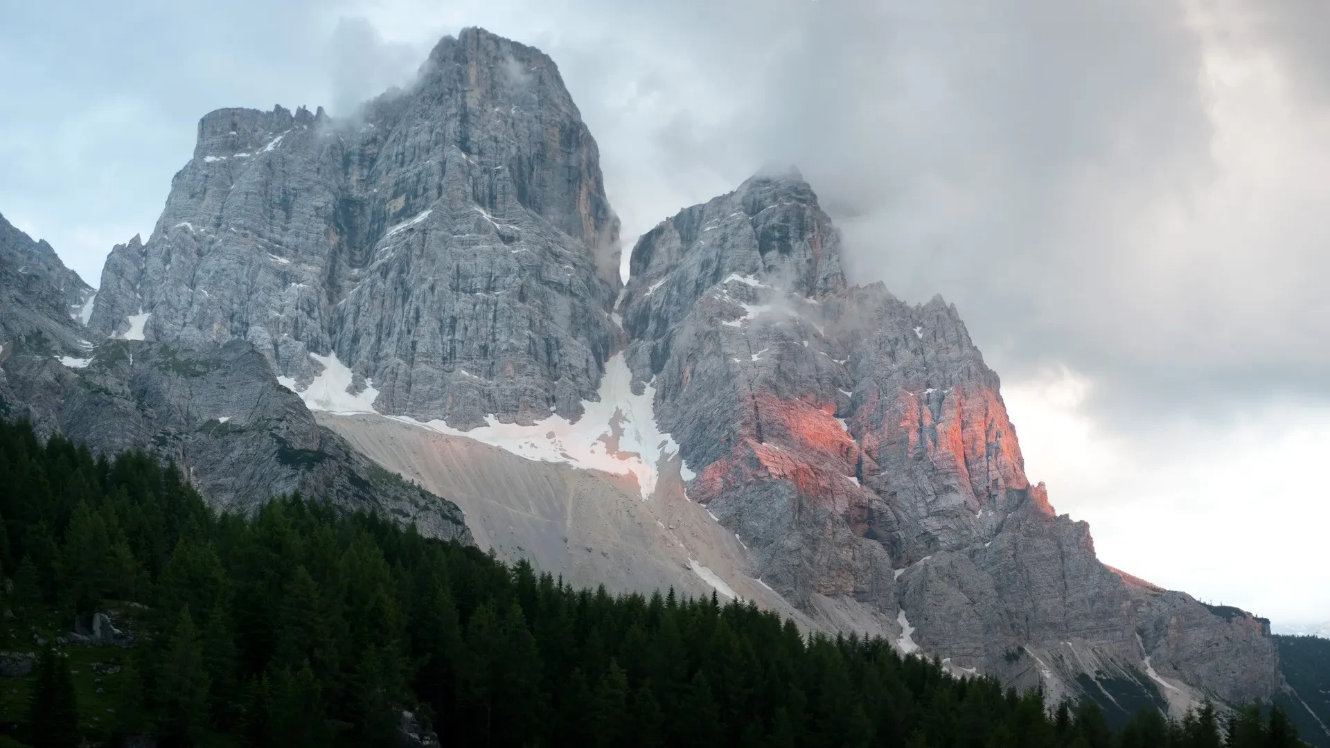 Hiker on the Alta Via 1 trail with dramatic Dolomite peaks in the background