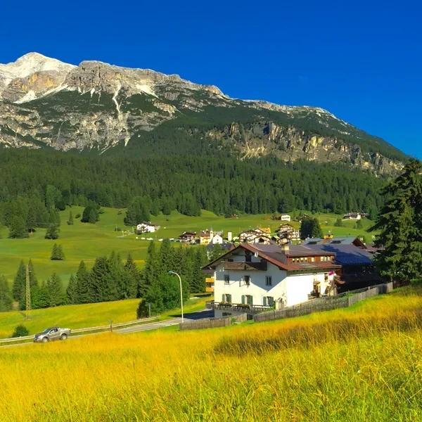 Cortina d'Ampezzo bell tower and rooftops in the Boite valley with the limestone walls of the surrounding Dolomites rising behind