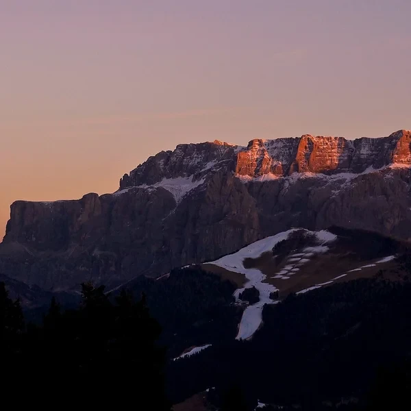 Les tours de dolomie du Catinaccio (Rosengarten) baignées dans une lumière rouge orangée au coucher du soleil