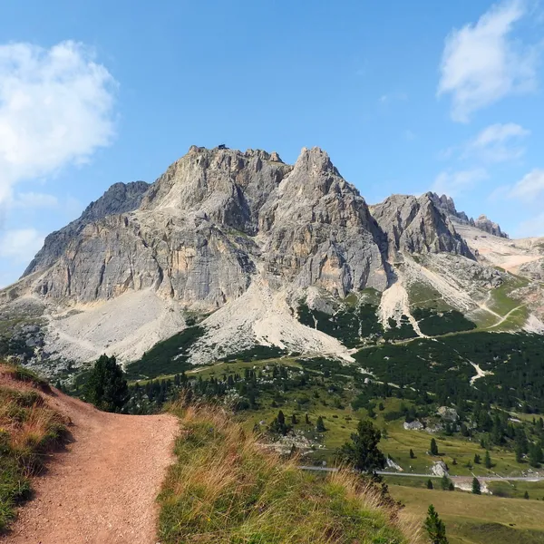 The Lagazuoi massif above the alpine pastures, seen from a trail on the Passo Falzarego side