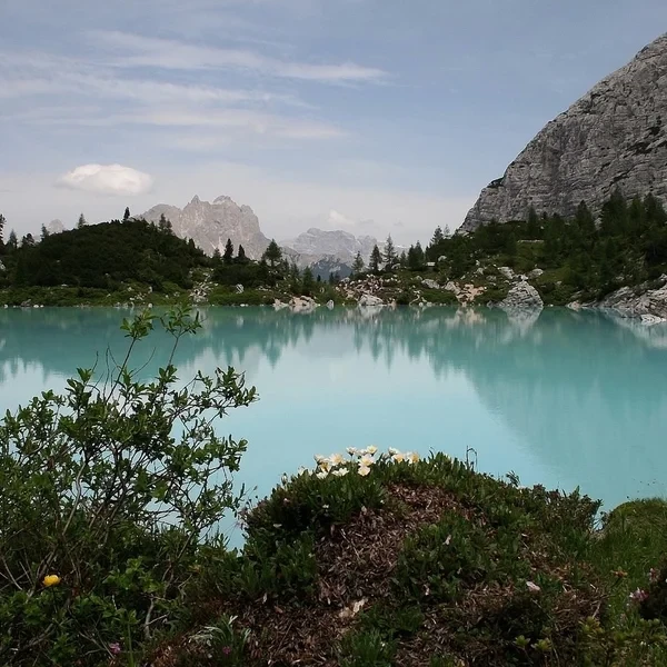 Eaux glaciaires turquoise du Lago di Sorapis entourées par les parois pâles des Dolomites