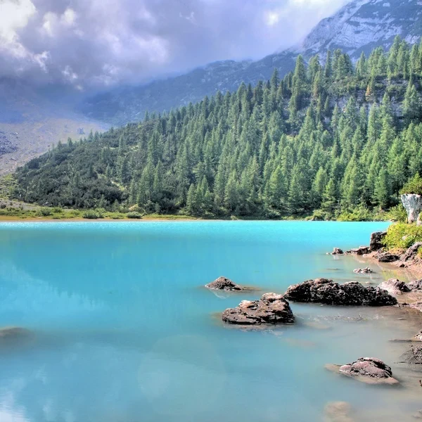 Turquoise glacial water of Lake Sorapis surrounded by pale Dolomite cliffs