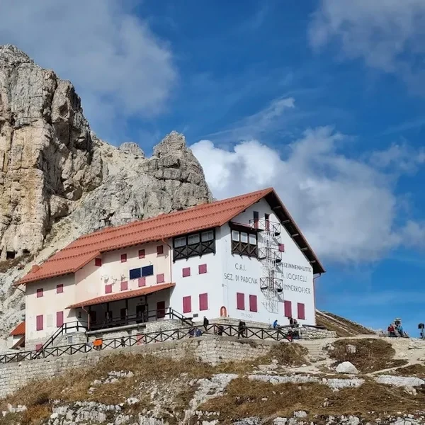 Rifugio Auronzo sitting at the base of the Tre Cime di Lavaredo at sunset.
