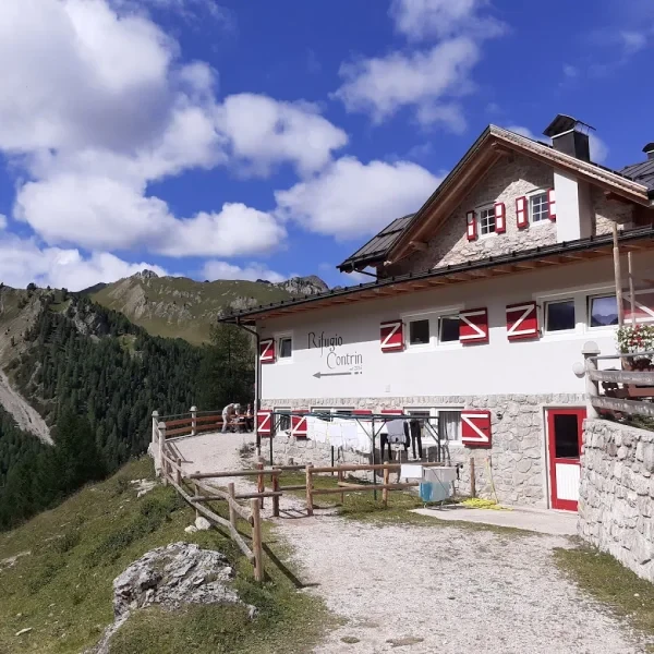 Rifugio Contrin in a green valley below the south face of the Marmolada glacier