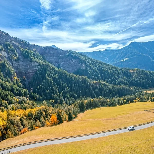 Autumn colors in Val Gardena with golden larch forests and green meadows below the Seceda ridge