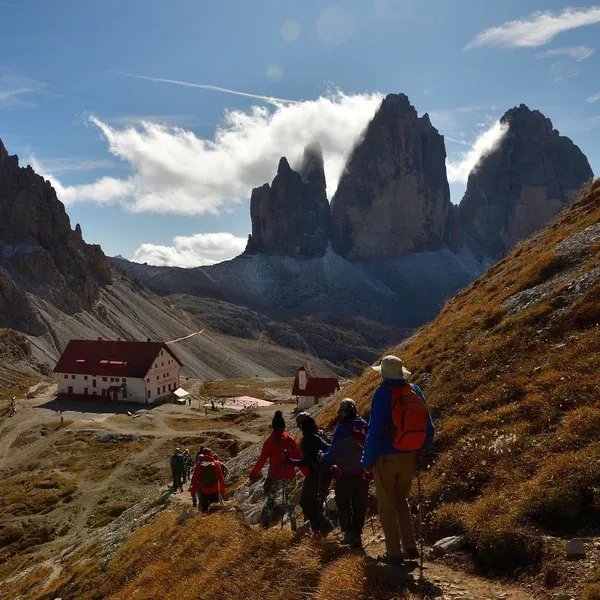 Hikers on the trail descending toward Rifugio Locatelli facing the three towers of Tre Cime di Lavaredo