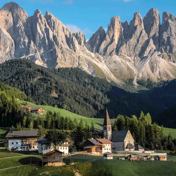 L'église blanche de San Giovanni in Ranui en Val di Funes (Villnöss) devant la paroi verticale du massif des Odle
